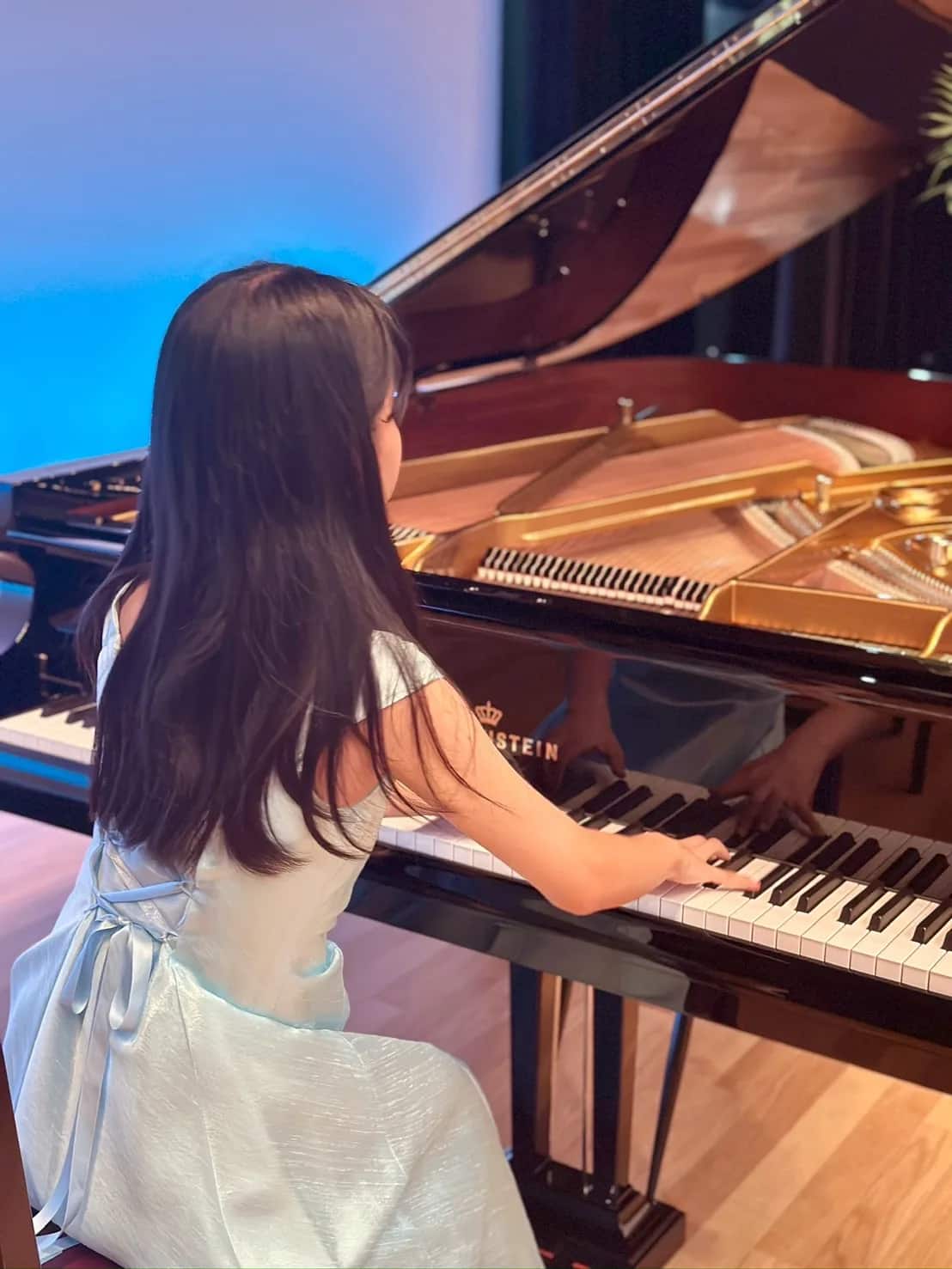 グランドピアノを演奏する生徒の後ろ姿